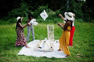 grupo de meninas afro-americanas comemorando festa de aniversário e se divertindo com almofadas ao ar livre com decoração. foto