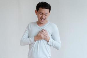 um homem tocando seu coração, com destaque vermelho de ataque cardíaco e outros conceito de doença cardíaca, sintoma de ataque cardíaco foto
