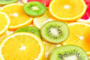 fatias de frutas cítricas - kiwi, laranjas e toranjas em fundo branco. cenário de frutas foto