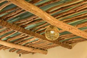 teto feito de toras de madeira com lanterna em forma de bola foto