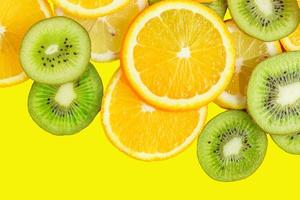 fatias de citrinos - kiwi, laranjas e limões em fundo amarelo. cenário de frutas foto