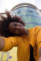uma mulher afro-americana feliz e jovem tira uma selfie, close-up foto