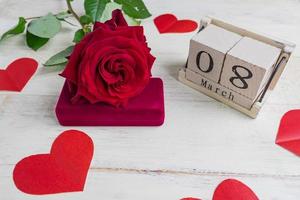 caixa de presente de joias com e lindas rosas vermelhas em fundo de madeira. cartão para o dia 8 de março. foto