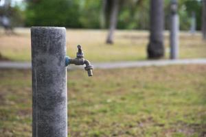 uma torneira de água velha no parque foto