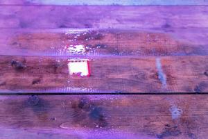 mesa de madeira molhada sob led cresce luz. textura de fundo foto