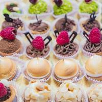 vitrine de pastelaria com variedade de mini sobremesas e bolos, foco seletivo foto