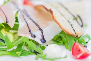 Salada de presunto de Parma com salada mista de folhas, vinagre balsâmico e queijo mussarela, foco suave.