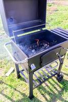 churrasqueira aberta com carvão quente pronto para cozinhar carne e legumes foto