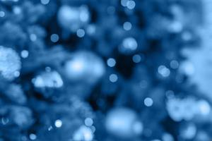 cor de tendência 2020 azul clássico, fundo de férias de natal e ano novo. árvores de natal desfocadas decoradas com bolas e guirlandas foto