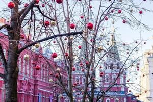 fundo de férias de natal e ano novo. árvore sem folhas decorada com bolas vermelhas e douradas foto