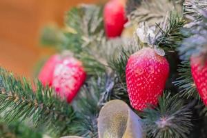 fundo de férias de natal e ano novo. árvore de natal decorada com morango, foco seletivo. conceito de celebração foto