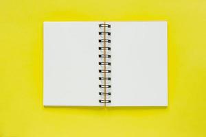 caderno espiral limpo para notas sobre fundo amarelo. mock up de configuração plana de negócios mínimos foto