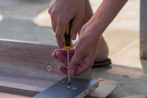 montagem de móveis - parafusos de carpintaria para uma mesa de madeira derrubada. foto