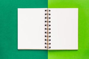 caderno espiral limpo para notas e mensagens sobre fundo verde. postura plana de negócios mínima foto