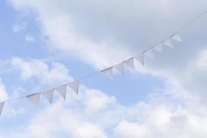 guirlanda de triângulo branco contra o céu azul. celebração ao ar livre decoração. conceito festivo foto