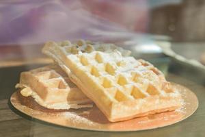 waffles vienenses assados na hora polvilhados com açúcar em pó em uma vitrine de caffe foto