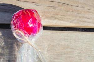 close-up de maçã vermelha caramelo sobre fundo de madeira. sobremesa doce da feira de rua foto