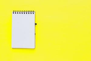 caderno espiral limpo para notas sobre fundo amarelo. mock up de configuração plana de negócios mínimos foto