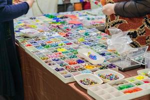 mistura colorida de contas de vidro lampwork. variedade de formas e cores para fazer colares ou pulseiras. materiais de bricolage no mercado foto
