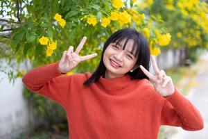 jovem retrato com flores amarelas, menina asiática. foto