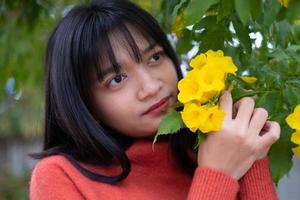 jovem retrato com flores amarelas, menina asiática. foto