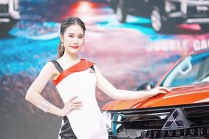 nonthaburi, tailândia - 3 de dezembro de 2019 modelo não identificado posa com um carro na 36th motor expo tailândia 2019 na arena de impacto, muang thong thani, nonthaburi, tailândia. foto