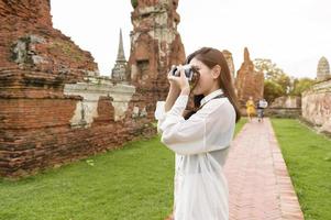 jovem mulher bonita viajando e tirando foto no parque histórico tailandês, feriados e conceito de turismo cultural.