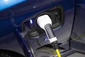 o carregamento da bateria para o carro novas inovações automotivas a fonte de alimentação conectada a um carro elétrico sendo carregado, conceito de inovação energética. foto