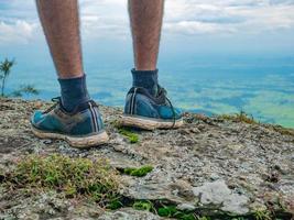 suporte de sapato de esporte turístico no penhasco de pedra com bela vista da montanha khao luang no parque nacional de ramkhamhaeng, província de sukhothai tailândia foto