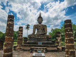 ruína da estátua antiga na área do templo wat mahathat no parque histórico de sukhothai, cidade de sukhothai tailândia foto