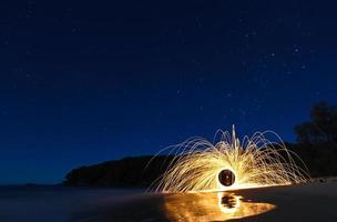 lã de aço noite estrelada na praia com reflexões foto