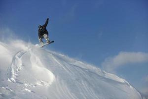 salto e passeio de snowboarder freestyle foto