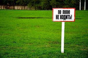 gramado de campo de futebol verde fresco colorido com placa proibida, sergiev posad, região de moscou, rússia foto