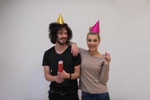 casal em chapéus de festa soprando no apito foto