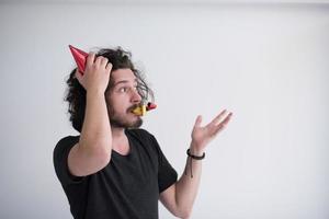 retrato de um homem com chapéu de festa soprando no apito foto