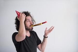 retrato de um homem com chapéu de festa soprando no apito foto