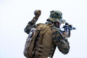 soldado em ação dando comandos à equipe por sinal de mão foto