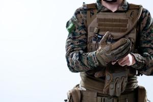 closeup de mãos de soldado colocando luvas de batalha protetoras foto