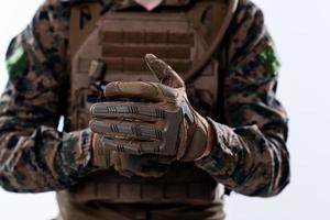 closeup de mãos de soldado colocando luvas de batalha protetoras foto