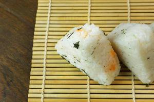 a comida japonesa onigiri arroz branco formado em formas triangulares ou cilíndricas e muitas vezes envolto em nori. foto