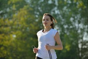 jovem mulher bonita correndo de manhã no parque foto