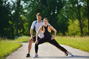 casal fazendo exercícios de alongamento depois de correr foto