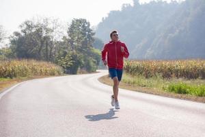 homem correndo ao longo de uma estrada rural foto