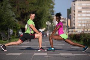 casal de jogging aquecendo e esticando na cidade foto