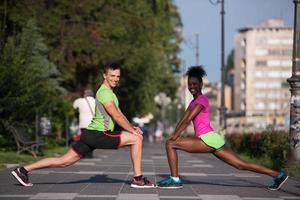 casal de jogging aquecendo e esticando na cidade foto