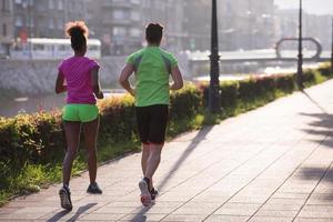 jovem casal multiétnico correndo na cidade foto