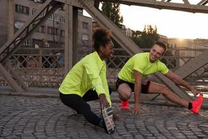 casal de jogging aquecendo e esticando na cidade foto