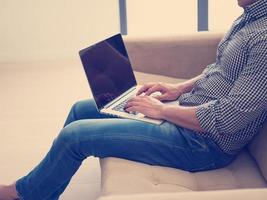 homem usando laptop na sala de estar foto