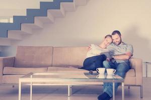 casal romântico relaxando em casa com computadores tablet foto