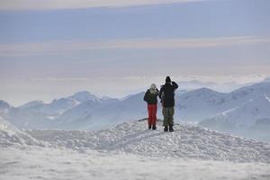 casal de snowboarder no topo da montanha foto